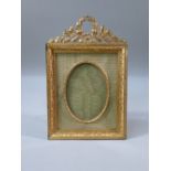 FRENCH GILT BRASS PHOTOGRAPH FRAME WITH AN OVAL APPERTURE, FLORAL DECORATION AND SURMOUNT (16.8 cm x