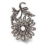 A VICTORIAN DIAMOND PENDANT/BROOCH in the form of a flowerhead and foliage, centred with an old-