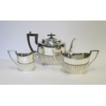 AN EDWARDIAN SILVER THREE-PIECE TEA SET, WALKER & HALL, SHEFFIELD, 1907 comprising: a teapot, a milk