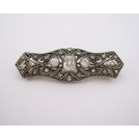 A VICTORIAN DIAMOND BAR BROOCH the open-work plaque centred with a cushion-cut diamond weighing
