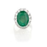 AN EMERALD AND DIAMOND RING centred with an oval mixed-cut emerald weighing approximately 5.93cts,
