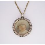 A LOCKET PENDANT of circular form, the glazed compartment with circular white gem surround and