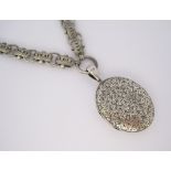A SILVER LOCKET PENDANT, EARLY 20TH CENTURY of oval form, opening to reveal a vacant compartment,