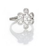 A DIAMOND RING in the form of a stylised flowerhead, set throughout with brilliant-cut diamonds