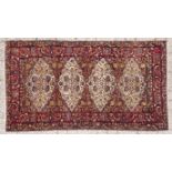 AN AFGHAN RUG, MODERN the dark blue field with three ivory floral medallions, all with flowering