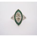 A DIAMOND AND EMERALD RING centred with a marquise-cut diamond weighing approximately 0.75cts