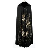 A Turn of the century silk cape.  Black velvet collar. Motif of butterflies and flowers beaded and