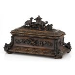 A carved oak deed box, 19th century of casket-shaped form, the hinged lid applied with two lambs and