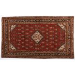 A Caucasian Rug, Azerbaijan, Modern the red field with a small ivory stepped medallion and spandrels