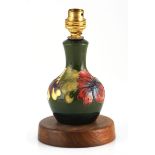 A Moorcroft 'Hibiscus' pattern lamp base, 20th century with a green ground and pink flowers, on a