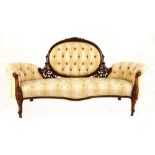 A Victorian carved walnut and upholstered settee, late 19th century the oval button-back above a