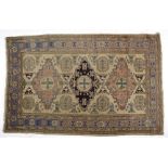 An Indo Persian Rug, Modern the ivory field with three geometric medallions in rose and dark blue