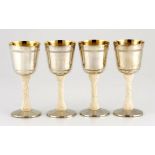 A set of four ivory stemmed and silver plated goblets each silvered bowl mounted on a leaf-carved