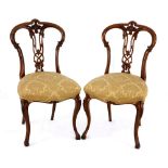 A pair of Victorian walnut side chairs, late 19th century each with an arched top rail with