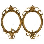 A pair of giltwood mirrors, 19th century each with an oval plate surmounted by a shell and C-