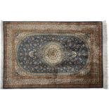 A fine Qum silk rug, Persia, Modern the sky blue field with a round floral ivory and pale green
