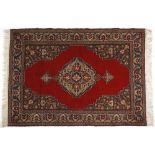 A Turkish Rug, Modern the plain red field with a stylised floral medallion depicted in gold and