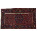 A Hamadan Rug, W. Persia, circa 1960 the red field with a stepped dark blue medallion all with