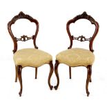 A pair of Victorian walnut balloon-back chairs, late 19th century each with an arched top rail and