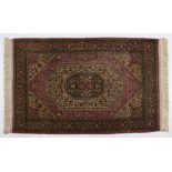 A Qum Rug, Persia, Modern the red field with a concentric ivory and dark blue floral medallion,