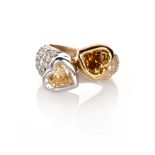 A DIAMOND RING, SCHWARTZ of crossover design, each terminal collet-set with a heart-shaped yellow