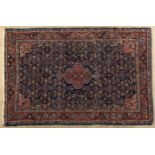 A HAMADAN RUG,PERSIA,CIRCA 1960 the deep blue field with a stepped madder-red medallion, similar