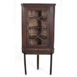 AN OAK CORNER CABINET-ON-STAND, 18TH CENTURY the moulded outswept cornice above an astragal glazed