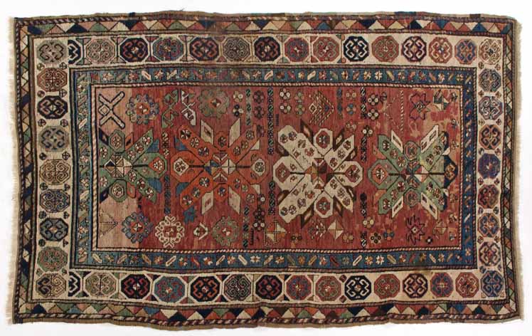A KAZAK-GENDJE RUG,CAUCASIA,CIRCA 1900 the red field with three cross-medallions depicted in ivory