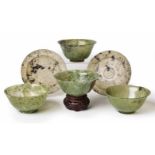 A GROUP OF FOUR CHINESE CARVED JADEITE BOWLS each of ogee form supported on a short straight foot,