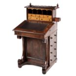 A VICTORIAN MAHOGANY AND SATINWOOD DAVENPORT the rectangular top surmounted by a shaped three-