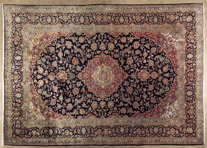 A KESHAN CARPET,PERSIA,MODERN the indigo-blue field with a red and ivory floral star medallion,