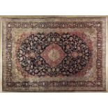 A KESHAN CARPET,PERSIA,MODERN the indigo-blue field with a red and ivory floral star medallion,