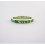 AN EMERALD ETERNITY RING the plain band channel set throughout with carré-cut emeralds, in 18ct