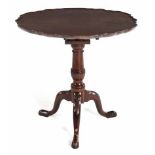 A VICTORIAN MAHOGANY PIE CRUST TILT-TOP TABLE the shaped top above a birds nest support, on a turned