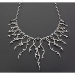 A DIAMOND NECKLACE designed as a series of intertwined tendrils, graduated in length, embellished