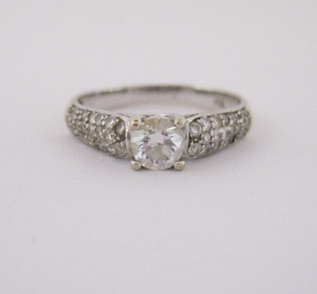 A DIAMOND RING centred with a claw-set brilliant-cut diamond weighing approximately 0.39cts, the