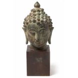 A THAI PATINATED BRONZE BUDDHA HEAD the serene face with smiling lips and downcast eyes
