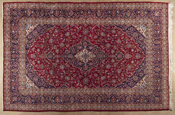 A KESHAN CARPET,PERSIA,MODERN the red field with a dark blue floral medallion and pendant, similar
