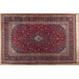 A KESHAN CARPET,PERSIA,MODERN the red field with a dark blue floral medallion and pendant, similar