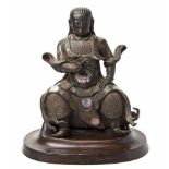 A CHINESE LACQUERED BRONZE AND MOTHER-OF-PEARL FIGURE OF A SEATED GUARDIAN FIGURE clothed in layered