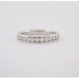 A DIAMOND HALF-ETERNITY RING channel set to the centre with brilliant-cut diamonds weighing