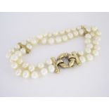 A DOUBLE-STRAND PEARL BRACELET composed of two strands of twenty-nine pearls each, with 9ct gold bar