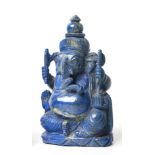 AN INDIAN CARVED LAPIS LAZULI FIGURE OF GANESH seated on a shaped base, his large belly falling over
