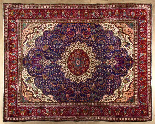 A TABRIZ CARPET,NORTH WEST PERSIA,MODERN the deep blue field with an ivory and red floral medallion,