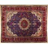 A TABRIZ CARPET,NORTH WEST PERSIA,MODERN the deep blue field with an ivory and red floral medallion,