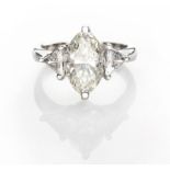 A DIAMOND RING centred with a marquise-cut diamond weighing 3.0250cts, flanked on either side by a