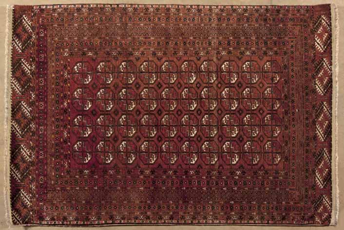 A AFGHAN RUG,MODERN the red field with four rows of Tekke guls depicted in ivory, red and walnut