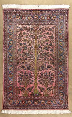 A KESHAN SILK RUG,PERSIA,CIRCA 1930 the red field with a bold ascending flowering tree and leaves