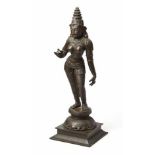 AN INDIAN PATINATED BRONZE FIGURE OF SRIDEVI standing in tribhanga with her right arm raised,