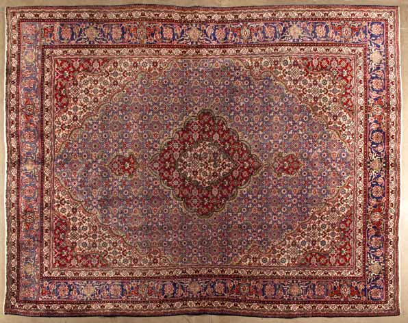 A TABRIZ CARPET,NORTH WEST PERSIA,MODERN the indigo-blue field with a red and ivory floral